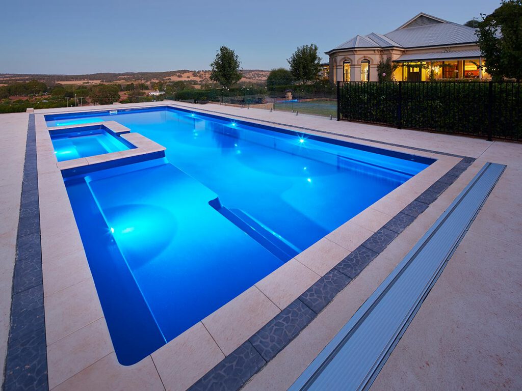 Sydney Harbour fiberglass pool model illuminated at night by Barrier Reef Pools LLC