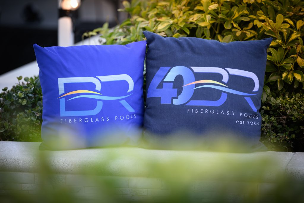 A view of a fully installed Barrier Reef fiberglass pool (possibly the [Pool Model Name] model) in an outdoor setting, showcasing the water color, integrated steps, and surrounding landscape.