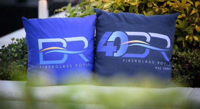 A view of a fully installed Barrier Reef fiberglass pool (possibly the [Pool Model Name] model) in an outdoor setting, showcasing the water color, integrated steps, and surrounding landscape.